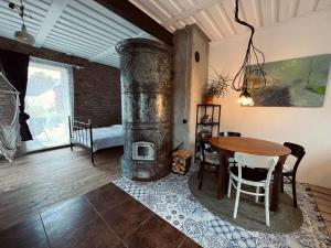 Pāvilostas Šīfermāja في بافيلوستا: غرفة معيشة مع طاولة ومدفأة