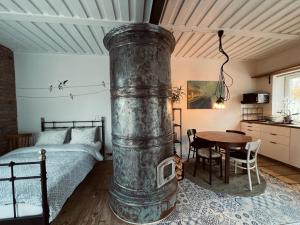 帕維洛斯塔的住宿－Pāvilostas Šīfermāja，一间卧室配有一张床和一张带炉灶的木桌