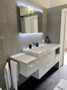 a bathroom with a white sink and a mirror at Melissa in Belluno