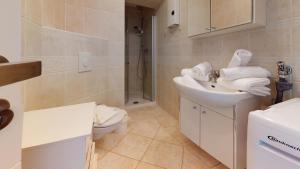 a white bathroom with a sink and a toilet at Ankerhaus Ankerhaus 2 in Hörnum +6 photos