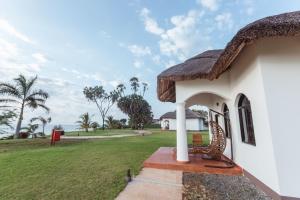 una casa con techo de paja y patio en Aya Sophia Villa Garden Hotel, en Dar es Salaam