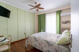 een slaapkamer met een bed en een plafondventilator bij Ioanna's Hellenic Hospitality in Athene