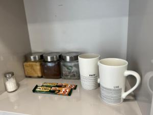 dos tazas de café blancas sentadas en un mostrador con especias en MOYA Apartmentai en Naujoji Akmenė