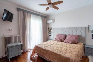 een slaapkamer met een bed en een plafondventilator bij Ioanna's Hellenic Hospitality in Athene