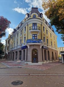 a large yellow building with a sign on it at Апартаменти Москва in Dobrich