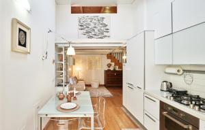 uma cozinha com armários brancos e uma pequena mesa em Loft del porto em Fano