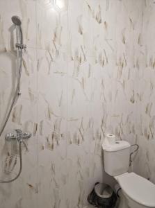 a white bathroom with a shower and a toilet at Апартаменти Москва in Dobrich