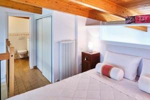 a bedroom with a white bed with a wooden ceiling at Loft del porto in Fano