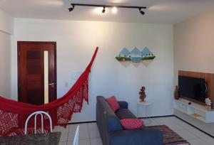 a living room with a hammock and a tv at Brisa Brasil Residence in Fortaleza