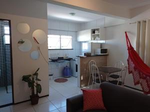 ein Wohnzimmer mit einem Sofa und einem Tisch sowie eine Küche in der Unterkunft Brisa Brasil Residence in Fortaleza