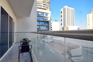 a balcony with a table and a view of a city at KeyHost - 1BR Apartment Near Five Hotel JVC - K141 in Dubai