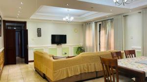 un soggiorno con divano e TV di PALATINE APARTMENTS MAKINDYE KIZUNGU, KAMPALA a Kampala