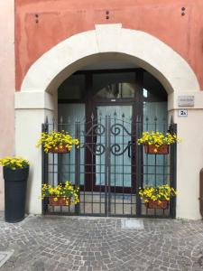 una entrada a un edificio con flores en la puerta en KINDLY ROBERTA centro storico Peschiera,lago relax en Peschiera del Garda