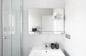 uma casa de banho branca com um lavatório e um espelho em Stunning and Spacious 4 Bed Apr next to BrickLane em Londres