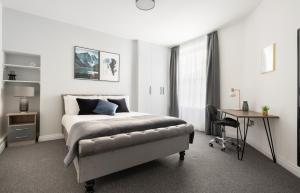 um quarto branco com uma cama e uma secretária. em Stunning and Spacious 4 Bed Apr next to BrickLane em Londres