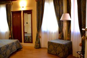a bedroom with two beds and a mirror and curtains at B&B Le Marie in Venice