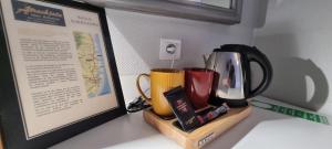 a counter top with two coffee mugs and a picture at Hôtel Restaurant Atrachjata in Aléria