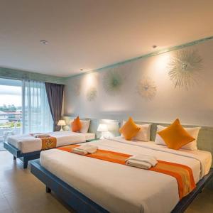 a bedroom with two beds with orange and white pillows at Baan Ban Dalay in Ao Nang Beach