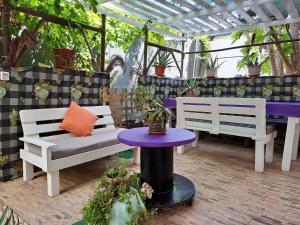 een patio met twee witte banken en een paarse tafel bij Apart-Hotel Ca Elsa in Sal Rei