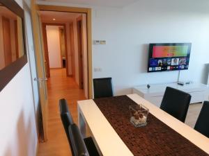 a dining room with a table and chairs and a tv at Apartment Airport Barcelona Premium in Viladecáns