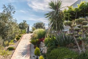 un jardín con muchas plantas y un camino en Cortijo Cabrilla, en Periana