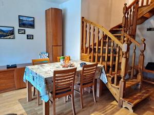a dining room table with chairs and a staircase at Espot Natura - Apartament de muntanya al PN Aigüestortes i Sant Maurici in Espot