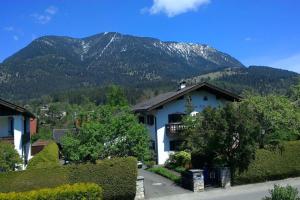 ein weißes Haus mit einem Berg im Hintergrund in der Unterkunft Herberge. 46 in Garmisch-Partenkirchen