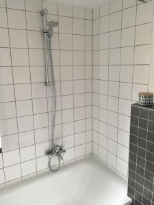 a shower in a bathroom with white tiles at Herberge. 46 in Garmisch-Partenkirchen