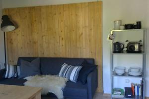 a blue couch in a room with a wooden wall at Herberge. 46 in Garmisch-Partenkirchen