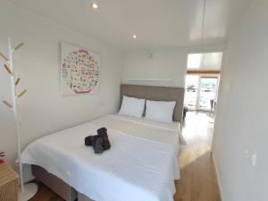 a bedroom with a bed with a stuffed animal on it at Blue Mind, heerlijk vakantiehuisje op het water: in Vinkeveen