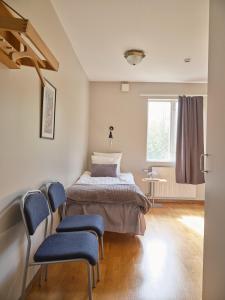 a bedroom with a bed and two chairs in it at Herrestad Bed & Guestroom in Värnamo