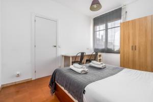 a bedroom with a bed with two chairs and a window at Arc De Triomf - Solar & Spacious in Barcelona