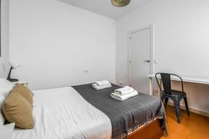 a bedroom with a bed with a chair and a desk at Arc De Triomf - Solar & Spacious in Barcelona