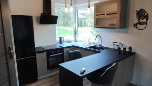 a kitchen with a black counter and a sink at Dobry Dom II in Staszów