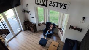 a woman sitting in a chair in a living room at Dobry Dom II in Staszów