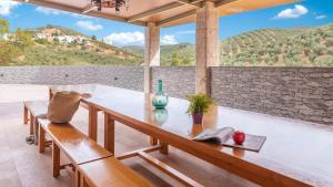 une table sur un porche avec vue sur une montagne dans l'établissement Cortijo Rural Los Pinos Villanueva de Algaidas by Ruralidays, à Villanueva de Algaidas