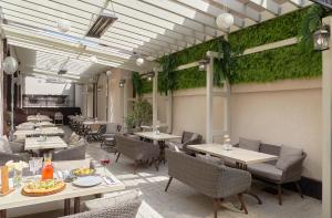 Un restaurante con mesas y sillas y plantas en la pared. en Garuda Boutique Hotel, en Sukhum
