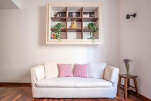um sofá branco com duas almofadas cor-de-rosa numa sala de estar em Appartamento nel cuore della città em Livorno