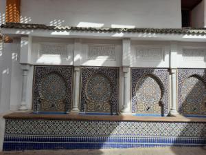 un edificio con piastrelle bianche e blu sul muro di DARY a Fes