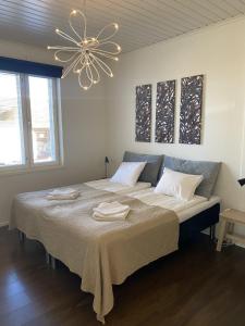 a bedroom with a large bed with two towels on it at Stava Mosters in Mariehamn