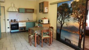 una cocina con mesa y una cocina con una pintura en KINDLY ROBERTA centro storico Peschiera,lago relax en Peschiera del Garda