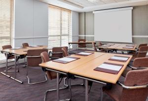 a classroom with tables and chairs and a whiteboard at Leonardo Hotel Newcastle - Formerly Jurys Inn in Newcastle upon Tyne