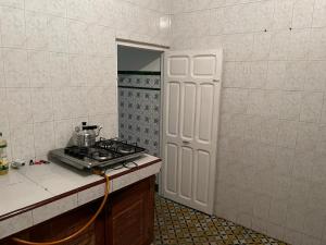 une cuisine avec cuisinière et une porte menant à une douche. dans l'établissement Appartement meublé, à Tetouan