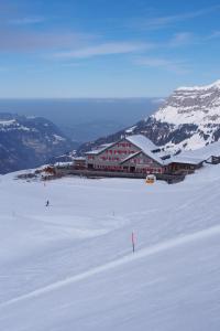 eine Skihütte im Schnee vor einem Berg in der Unterkunft Bärghuis Jochpass - Alpine Hideaway - 2222müM in Engelberg