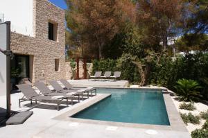 una piscina con tumbonas junto a una casa en Extravagant Ibiza Villa Casa Tranquila SArgamassa 5 Bedrooms Fantastic Sea Views and Private Pool Santa Eulalia en Santa Eulalia del Río