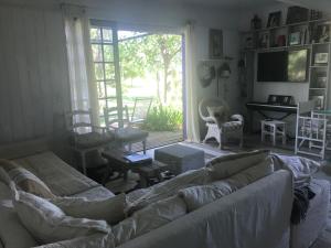 sala de estar con sofá y ventana grande en Capilla-Casa de campo en Capilla del Señor