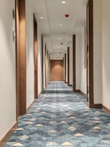 un pasillo de un edificio de oficinas con un pasillo de moqueta en Chryso Hotels Pvt Ltd, en Ankleshwar
