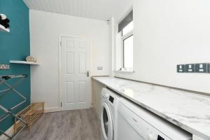 uma lavandaria com uma máquina de lavar roupa e uma janela em Modern Town House in Chesterfield & The Peaks em Newbold