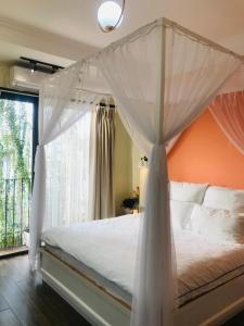 a bedroom with a canopy bed with a window at Chez Madame Binh in Hanoi