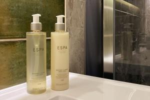 two shampoo bottles sitting on top of a bathroom counter at Luxury tree-house with optional ESPA Spa in Canterbury